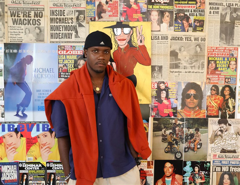 Standing portrait against a music magazine wall