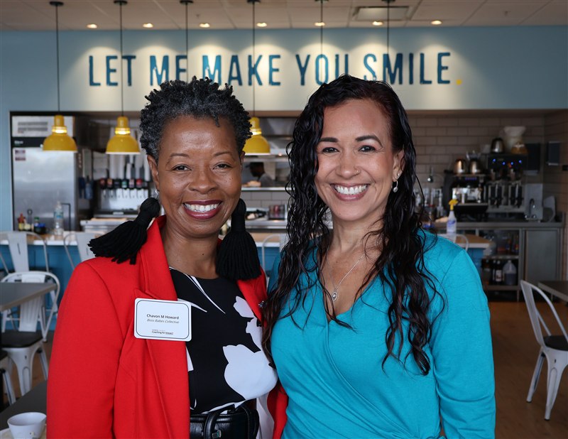 Two attendees smiling at the breakfast gathering